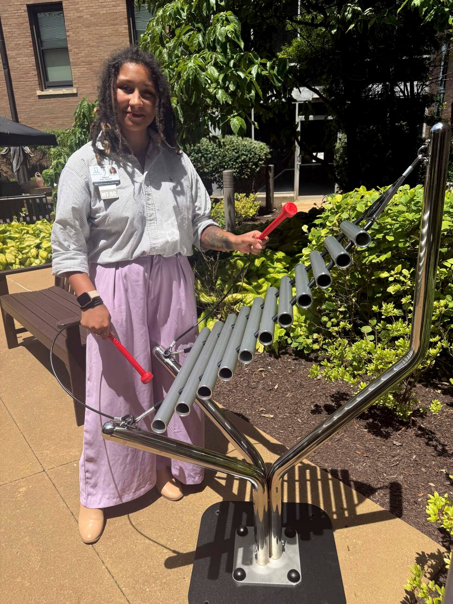 Woman standing outside next to an outdoor xylophone instrument