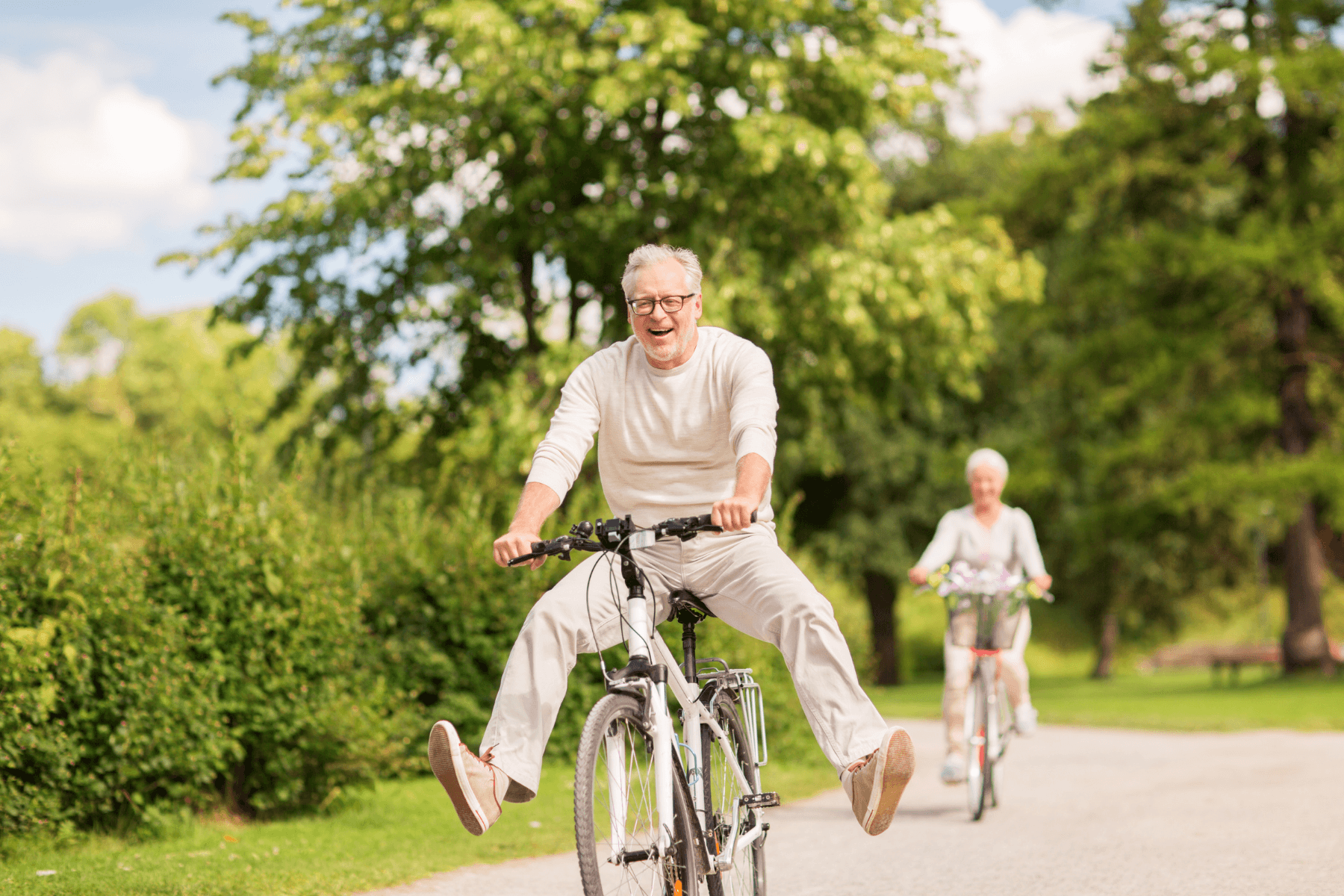 When-to-move-to-senior-living - Evertrue older couple riding bikes outside smiling and laughing